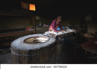 KAKHETI, GEORGIA - JUNE 16, 2016: Georgian Aged Woman Makes Traditional Bread In Old Round Stone Oven In Kakheti Rural Village.