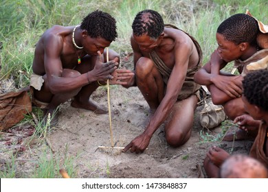 KALAHARI DESERT - BOTSWANA - DECEMBER 31, 2010: Unidentified men of the Bushmen tribe light a fire in the Kalahari Desert, Botswana.