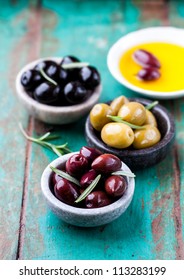 Kalamata, Green and Black Olives with Fresh Rosemary and Olive Oil on rustic wooden background. Concept for a tasty and healthy appetizer. - Shutterstock ID 113283199