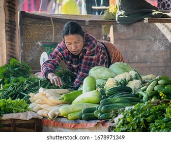 Kalaw, Myanmar (Burma) - January 31, 2018: Burmese Female Shop Keeper Arranging Produce At Her Stall The Local Market In Kalaw. Candid Street Life Scene.