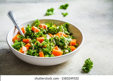 Kale And Baked Sweet Potato Salad With Tahini Dressing In White Bowl.