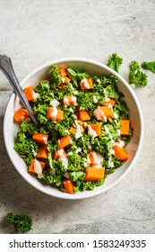 Kale And Baked Sweet Potato Salad With Tahini Dressing In White Bowl.