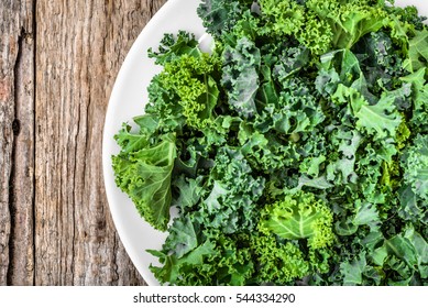 Kale. Green vegetable leaves, top view on white plate, healthy eating, vegetarian food. - Powered by Shutterstock