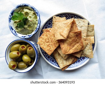 Kale Hummus With Green Olives And Pita Chips On Napkin