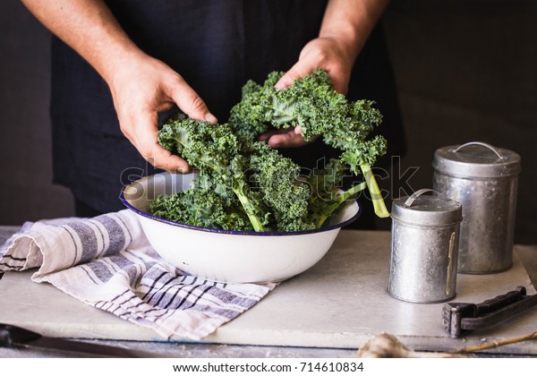 Kale leafy greens\
vegetable box hold in hands wash black wall raw kale ready to\
prepare food hand greens\
leafy