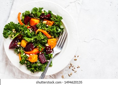 Kale Salad With Baked Sweet Potato, Carrot And Beet In A White Plate.