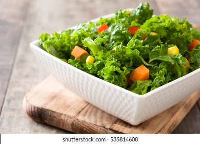 Kale Salad In White Bowl On Wooden Table