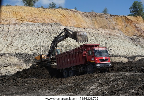 kalimantan, 24 april\
2022, loading coal, a hyundai 400 series excavator loading coal\
into a tata dumptruck\
vessel