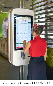 KALININGRAD, RUSSIA - CIRCA SEPTEMBER, 2018: woman use self ordering kiosk in McDonald's restaurant. McDonald's is an American fast food company.