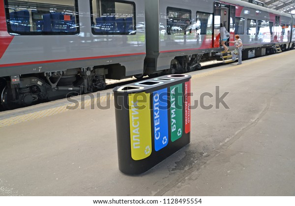 KALININGRAD, RUSSIA - JUNE 20, 2018: The container\
for separate collecting garbage costs on the platform of the\
Southern station. The Russian text - plastic, glass, paper, not\
sorted waste