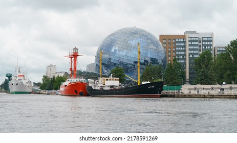 Kaliningrad, Russia - June 21, 2022:   Museum Of The World Ocean. Building Is In Form Of Glass Ball. Irbensky Floating Lighthouse. Moored On Pregolya River. SRT-129 Is Medium Fishing Trawler
