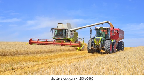Kalush, Ukraine - August 4: Overloading grain harvester in tractor trailer tank in the field near the town Kalush, Western Ukraine August 4, 2015
