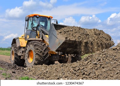 Kalush, Ukraine  July 12, 2018: The JCB bucket loader is repairing a section of a dirt road near the town of Kalush, Western Ukraine.