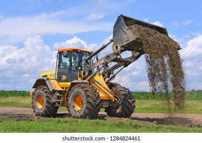 Kalush, Ukraine  July 12, 2018: The JCB bucket loader is repairing a section of a dirt road near the town of Kalush, Western Ukraine.