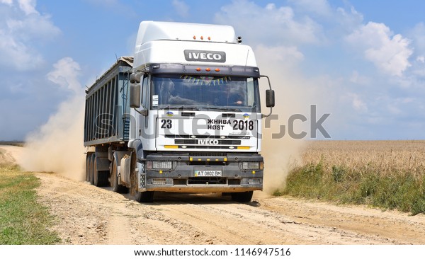 Kalush, Ukraine  July 12, 2018: A heavy-duty\
truck with a grain load on a dirt road through a field near the\
town of Kalush, Western\
Ukraine.