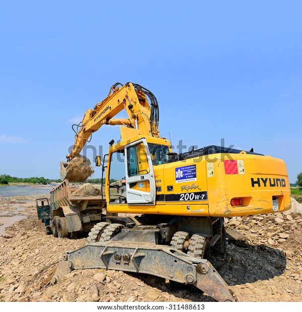 Kalush, Ukraine - July 8: Loading\
boulders in the car body on the construction of a protective dam\
near the town of Kalush, Western Ukraine July 8,\
2015