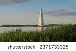 Kalyazin,  Tver region, Russia, 06-24-2022:  the flooded bell tower of St. Nicholas Cathedral on the artificial island of the Uglich reservoir of the Volga River, reeds at shore