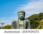 Kamakura, the Great Buddha of Kamakura a large bronze Buddha Statue at the Kotokuin Temple during autumn in Japan with blue sky and copy space.