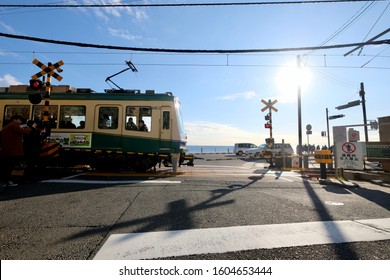 Kamakura, Kanagawa. Japan-Dec.2019: Train Of The Enoshima Electric Railway Passing Through Railroad Crossing Near Kamakurakokomae Station. Under Sunny Blue Sky. Famous Scene In Cartoon Slam Dunk