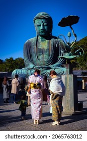 Kamakura, Kanagawa Prefecture, Japan - October 23, 2021: Two unidentified women, dressed in formal kimonos, visit the Great Buddha or or Kamakura Daibutsu which was completed in 1252.