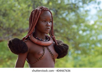 KAMANJAB, NAMIBIA - FEB 1, 2016: Young unidentified Himba woman with typical hairstyle shown in himba village