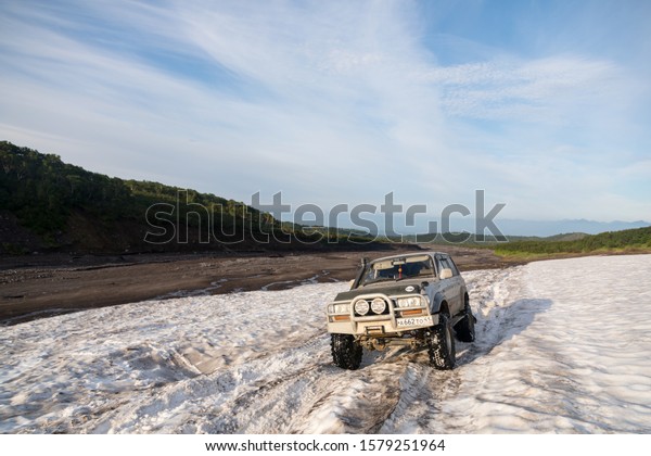 KAMCHATKA PENINSULA, RUSSIA - AUGUST 08, 2018:\
SUV Toyota Land Cruiser storms a\
glacier