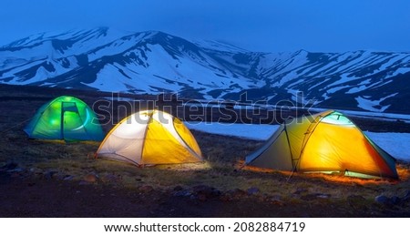 Kamchatka Peninsula, Russia. 
Tourist tents on the background of volcanoes. Mountaineering and hiking in Kamchatka
