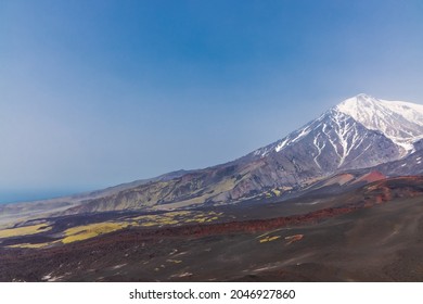 Kamchatka rocks from volcanic rocks multi-colored volcanic rocks. Crumbling volcano craters. against the backdrop of volcanoes with peaks in the snow and clouds. Ostry Tolbachik and Plosky Tolbachik. - Shutterstock ID 2046927860
