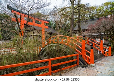 Kamigamo Jinja, a Shinto shrine in Kyoto, Japan. Religious Japanese architecture with small bridge and Torii gate painted red. 