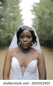 Kampala, Central, Uganda 24- 07- 2021
Close Up Of African American Bride On  Wedding Day In The Gardens Takes A Photo Standing Looking Into The Camera With A Huge Smile And The Background Is In Blur