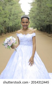 Kampala, Central, Uganda 24- 07- 2021
Close Up Of African American Bride On  Wedding Day In The Gardens Takes A Photo Standing Looking Into The Camera With A Huge Smile And The Background Is In Blur