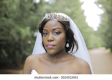 Kampala, Central, Uganda 24- 07- 2021
Close Up Of African American Bride On  Wedding Day In The Gardens Takes A Photo Standing Looking Into The Camera With A Huge Smile And The Background Is In Blur