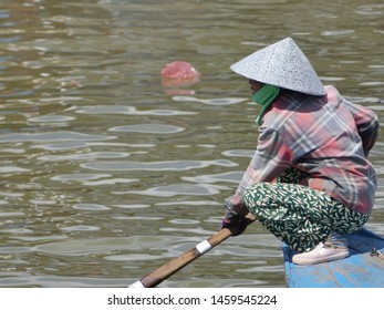 KAMPONG CHHNANG, CAMBODIA –  NOV 8 2018: A vietnamese woman on a boat near the floating village. 