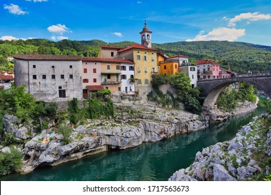 Kanal ob Soči in Slovenia. View of beautiful colorful buildings standing on a stone with Soča river and bridge. 