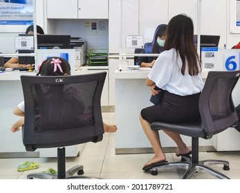 KANCHANABURI, THAILAND - AUGUST 27, 2020 : Unidentified Asian  Female Customer  Transact With Bank Staff During Coronavirus (Covid-19) Pandemic At TMB Bank Public Company Limited.New Normal Lifestyle.