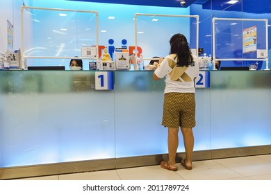 KANCHANABURI, THAILAND - AUGUST 27, 2020 : Unidentified Asian Female Customer  Transact With Bank Staff During Coronavirus (Covid-19) Pandemic At TMB Bank Public Company Limited. New Normal Lifestyle.