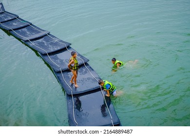 Kanchanaburi, Thailand - May 28, 2022:  During the summer semester break, three boys went to play on the rafts at Srinakarin Dam. Kanchanaburi - image 