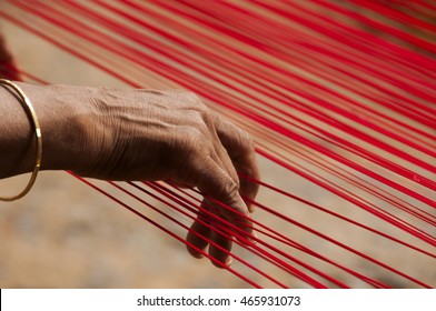 KANCHIPURAM, INDIA - 18 AUGUST 2010 : unidentified  weavers Removing knots and drying silk yarn for  weaving silk sari on loom. Kanchipuram is famous for hand woven silk sarees.