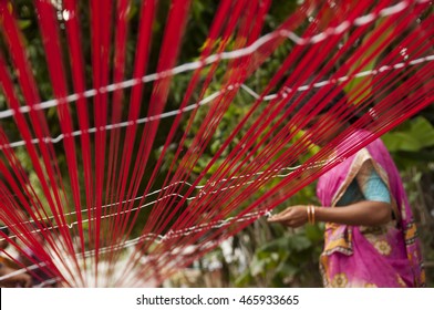 KANCHIPURAM, INDIA - 18 AUGUST 2010 : unidentified  weavers Removing knots and drying silk yarn for weaving silk sari on loom. Kanchipuram is famous for hand woven silk sarees.
