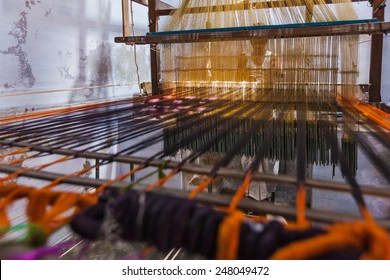 KANCHIPURAM, INDIA - SEPTEMBER 12, 2009: Man weaving silk sari on loom. Kanchipuram is famous for hand woven silk sarees and most of the city's workforce is involved in  weaving industry
