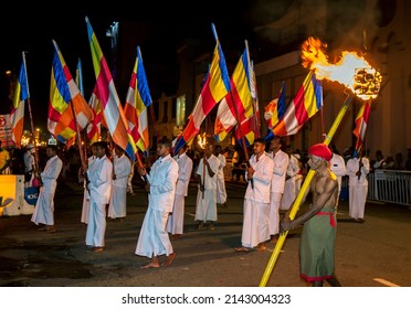 KANDY, SRI LANKA - AUGUST 25, 2015 : Buddhist Flag Bearers and a Torch Carrier parade along a street at Kandy in Sri Lanka during the Esala Perahera (great procession).