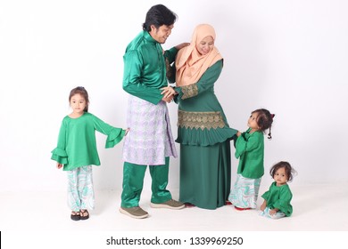 KANGAR, PERLIS, MALAYSIA,15th MARCH 2019: Asian Muslim Family Enjoying Quality Time Together With Traditional Clothes Celebrating Eid Mubarak On White Studio. Malay Family During Hari Raya Aidilfitri