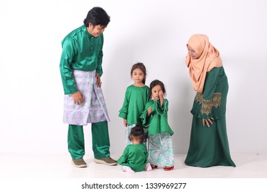 KANGAR, PERLIS, MALAYSIA,15th MARCH 2019: Asian Muslim Family Enjoying Quality Time Together With Traditional Clothes Celebrating Eid Mubarak On White Studio. Malay Family During Hari Raya Aidilfitri