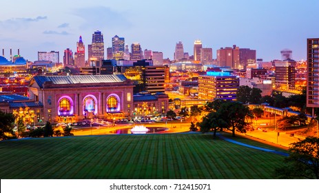 Kansas City, Missouri cityscape skyline as night falls over downtown (logos blurred for commercial use)