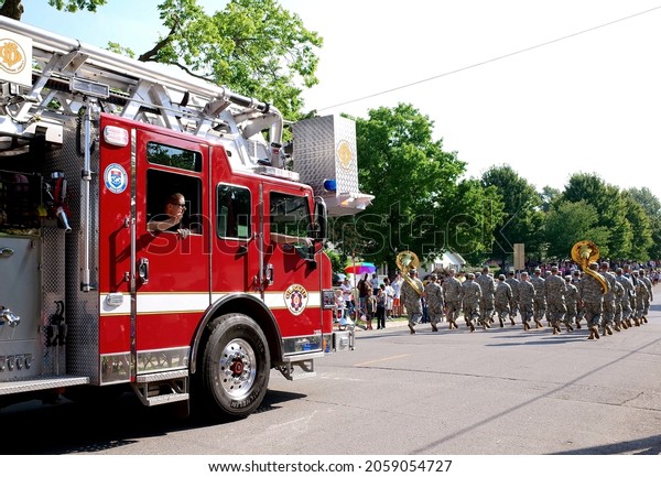 KANSAS CITY, UNITED STATES - Sep 10, 2013: A\
horizontal shot of a red fire truck and walking soldiers during the\
parade  Kansas, US