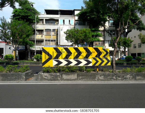 Kaohsiung, Taiwan, October 18, 2020: On the small\
island separated by the road, put a group of yellow arrows pointing\
forward