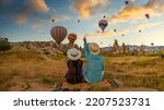 Kapadokya Cappadocia Turkey, a happy young couple during sunrise watching the hot air balloons of Kapadokya Cappadocia Turkey during vacation. Asian women and caucasian men on holiday in Turkey