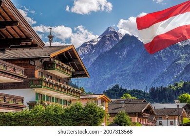 Kaprun village with hotel against Kitzsteinhorn glacier and Austrian flag in Salzburg region, Austrian Alps, Austria
