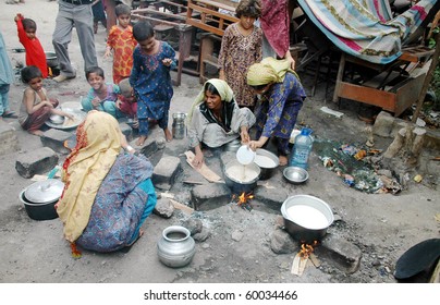 KARACHI, PAKISTAN - AUG 29: Flood affected people prepare food at a flood relief camp on August 29, 2010 in Karachi.