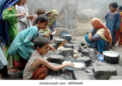 KARACHI, PAKISTAN - AUG 29: Flood affected children cook food at a flood relief camp on August 29, 2010 in Karachi.
